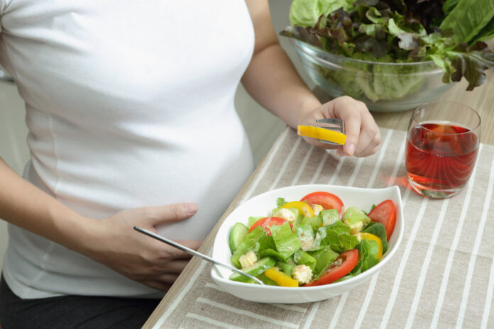 Dieta w ciąży – ciężarna kobieta jedząca zdrową sałatkę