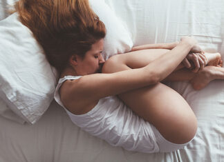 Choroba wdowia - smutna młoda kobieta leżąca w łóżku