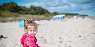 Nocleg Hel – dziewczynka siedząca na plaży w pobliżu Helu