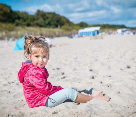 Nocleg Hel – dziewczynka siedząca na plaży w pobliżu Helu