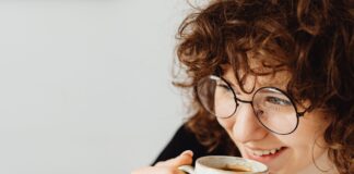 Kawa, herbata i codzienne nawyki a kolor zębów – skąd biorą się przebarwienia? kobieta w okularach pijąca kawę